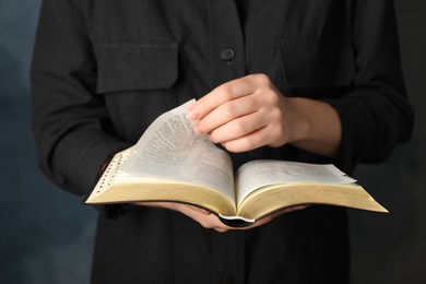 Photo of Humble woman reading Bible, closeup. Religious literature
