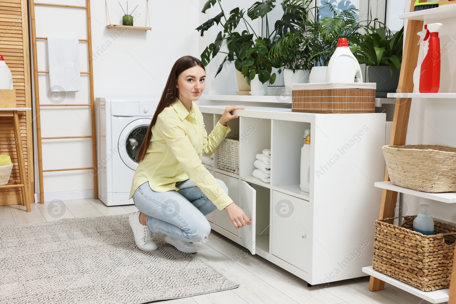 Photo of Beautiful young woman in modern laundry room