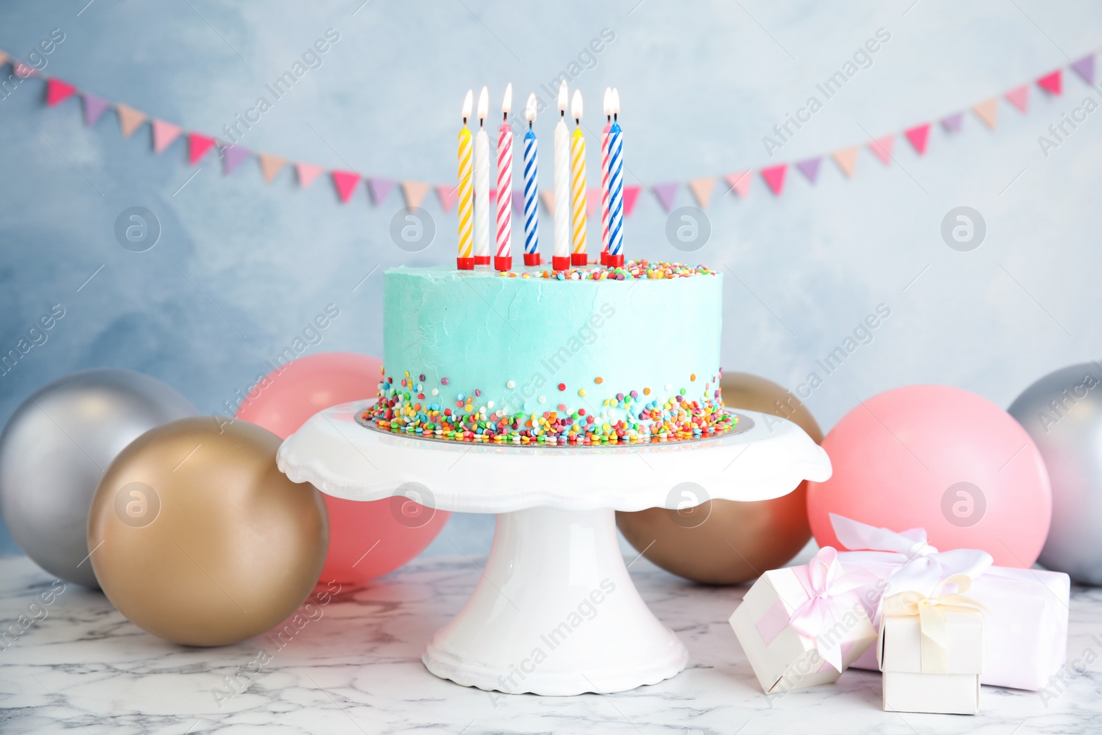 Photo of Fresh delicious birthday cake, gifts and balloons on table against color background