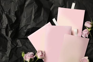 Photo of Scented sachets and roses on black crumpled paper, flat lay. Space for text