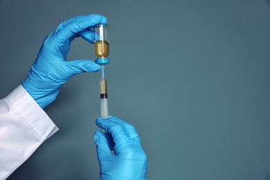 Photo of Doctor with syringe and medicine for vaccination on color background