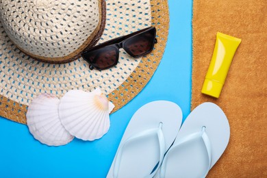 Flat lay composition with beach accessories on light blue background
