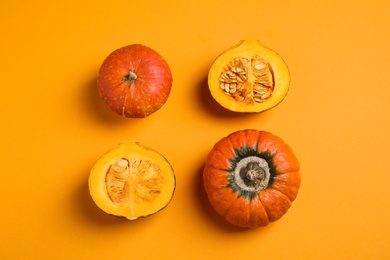 Photo of Fresh ripe pumpkins on orange background, flat lay. Holiday decoration