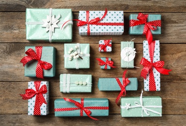 Photo of Different Christmas gift boxes on wooden background, flat lay