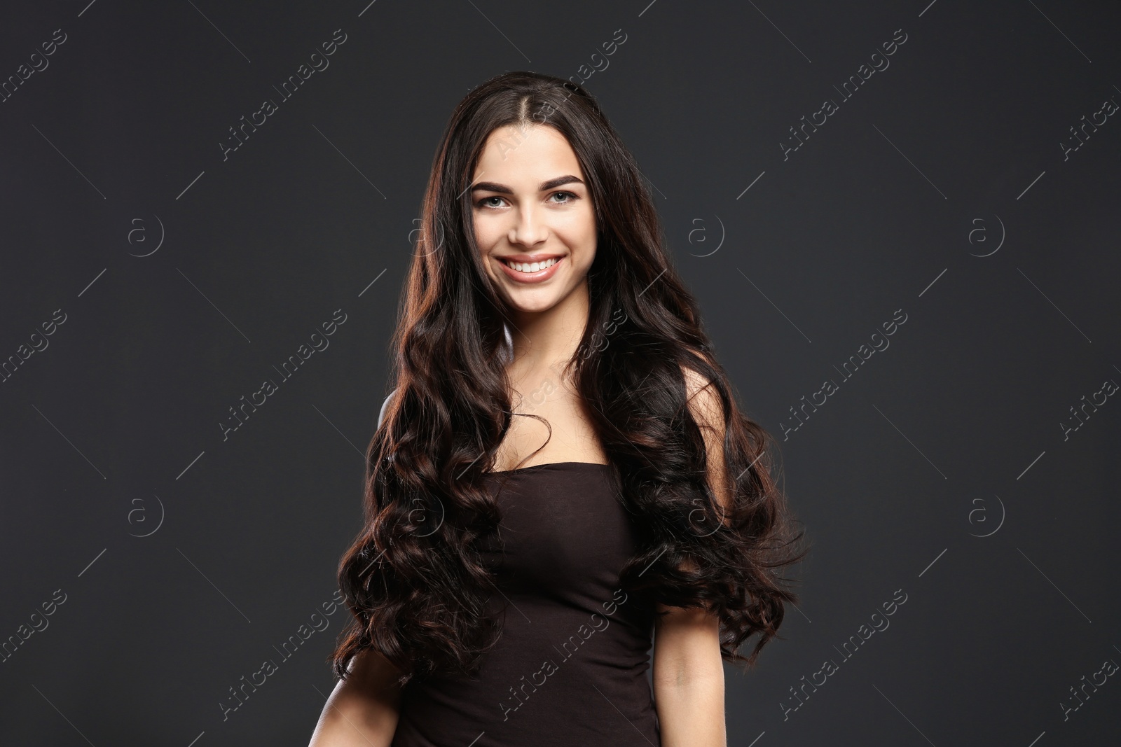 Photo of Portrait of beautiful model with gorgeous curly hair on black background