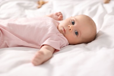 Cute little baby lying on white sheets