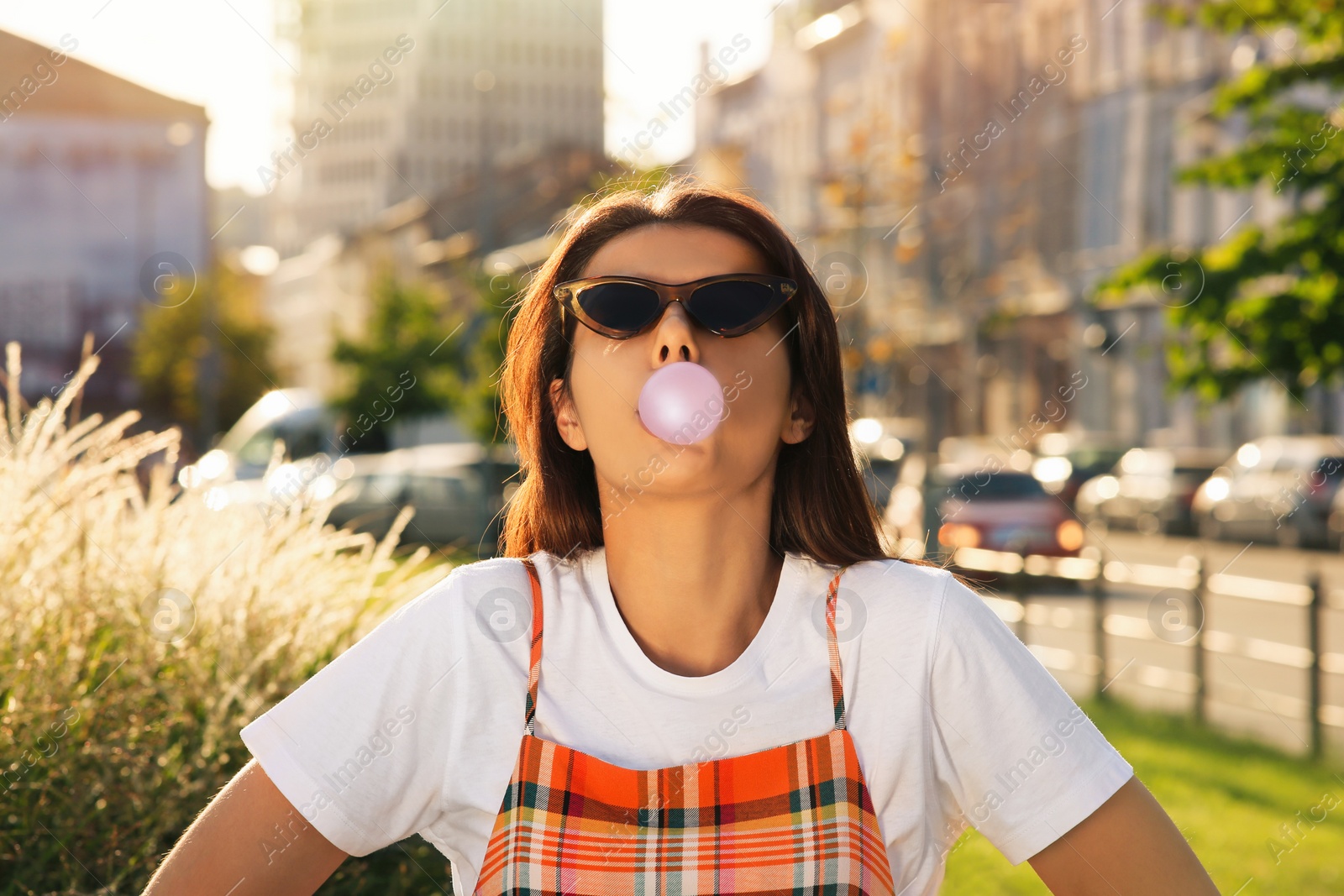 Photo of Beautiful woman blowing gum on city street