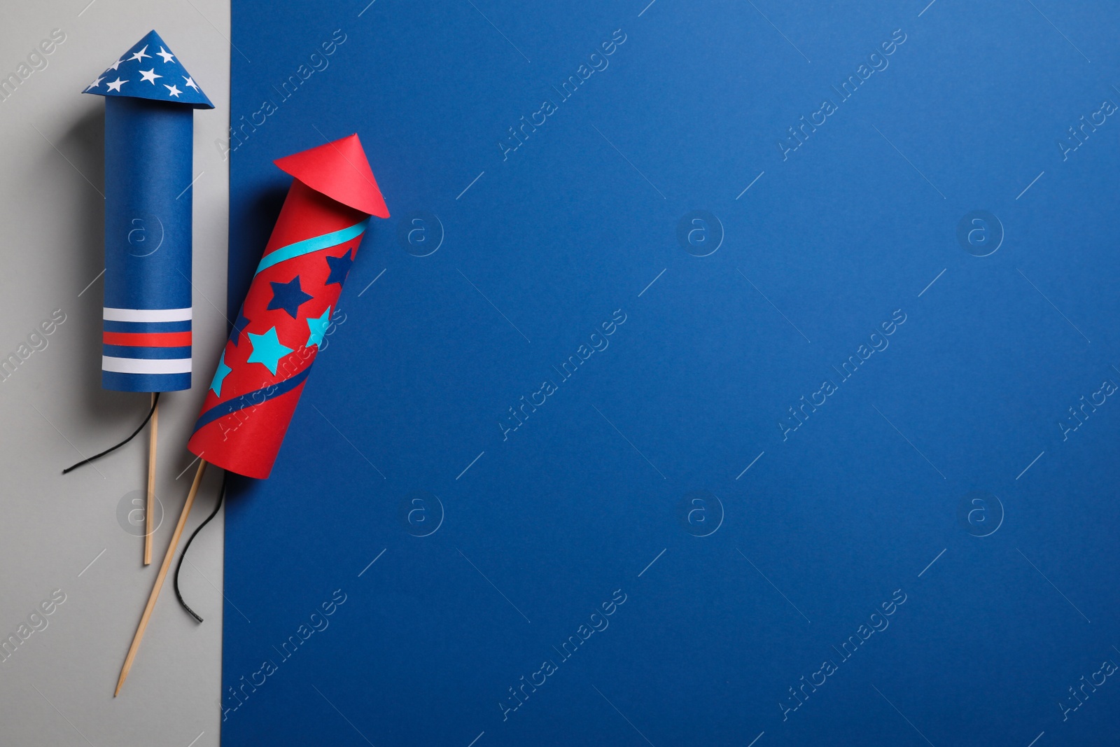 Photo of Firework rockets on color background, flat lay with space for text