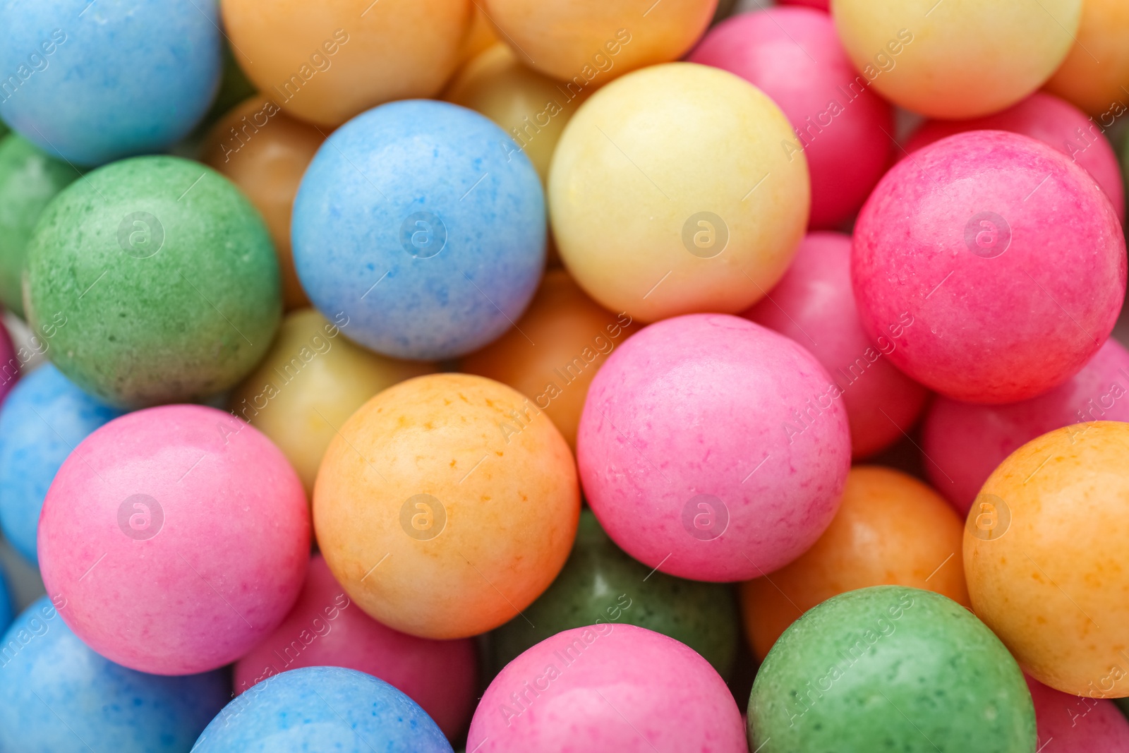 Photo of Many bright chewy gumballs as background, top view