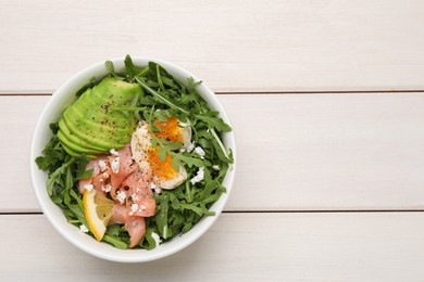 Delicious salad with boiled egg, salmon and avocado in bowl on white wooden table, top view. Space for text