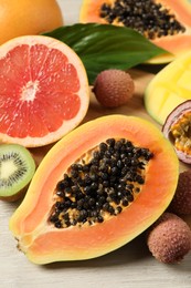 Photo of Fresh ripe papaya and other fruits on white wooden table