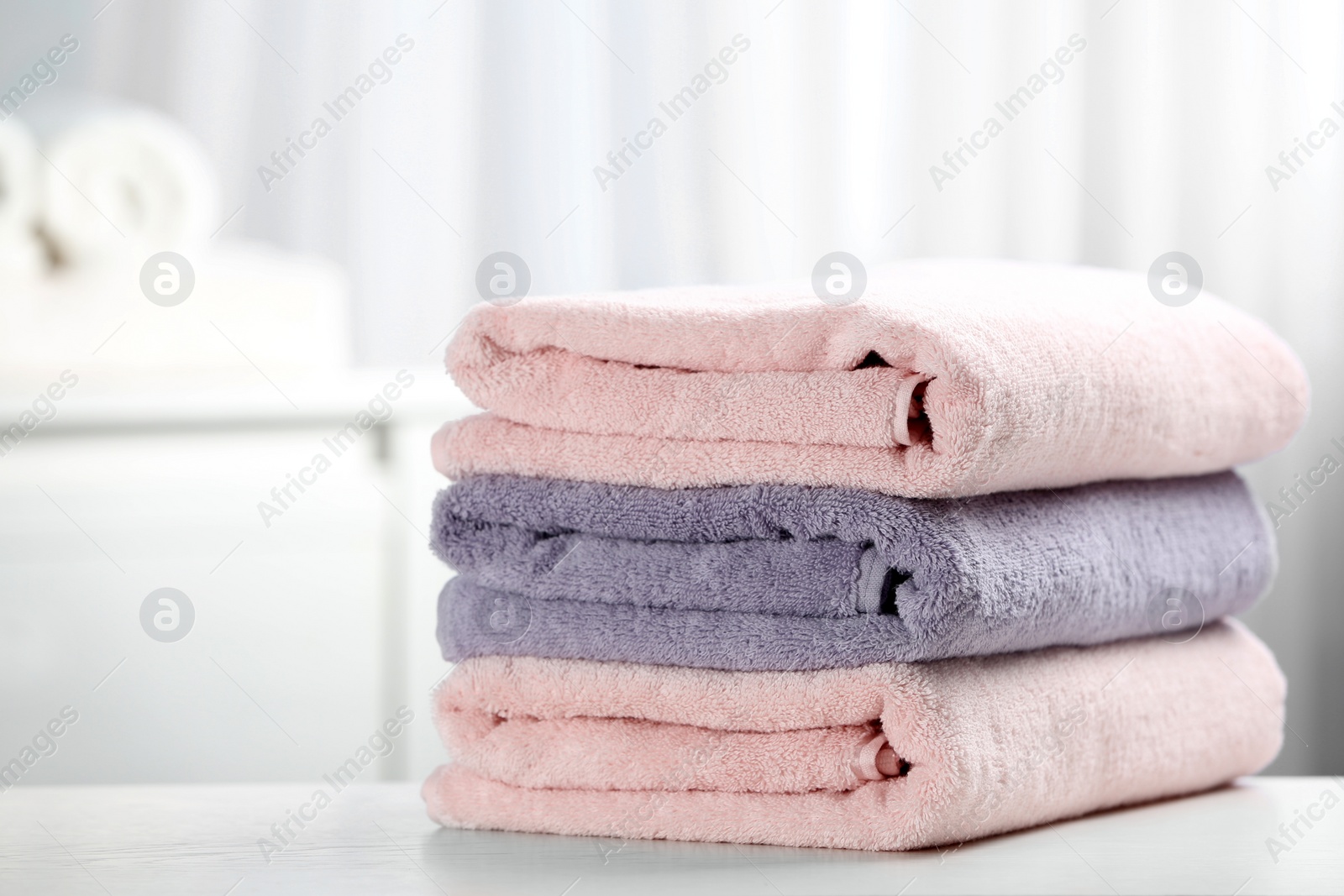 Photo of Stack of fresh towels on table. Space for text