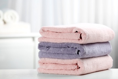 Photo of Stack of fresh towels on table. Space for text