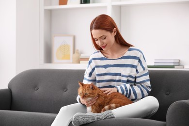 Photo of Woman with her cute cat on sofa at home