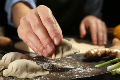 Photo of Woman making gyoza at table, closeup view