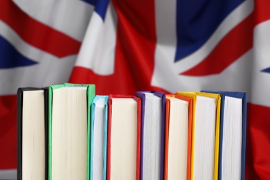 Learning foreign language. Different books against flag of United Kingdom, closeup