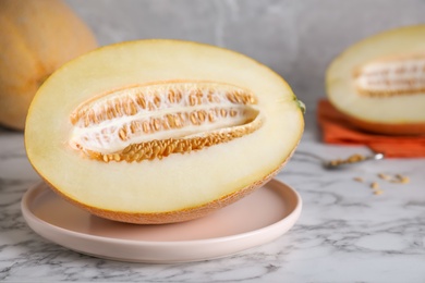 Photo of Delicious honey melon on white marble table
