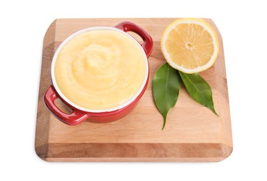 Photo of Delicious lemon curd in bowl, fresh citrus fruit and green leaves isolated on white