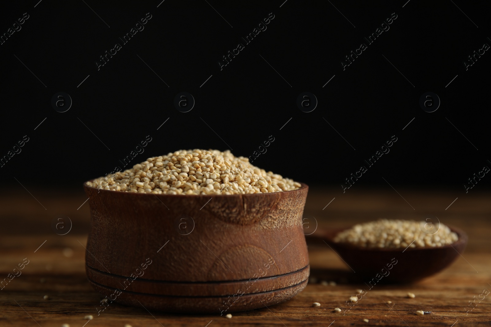 Photo of Bowl with white quinoa on wooden table. Space for text