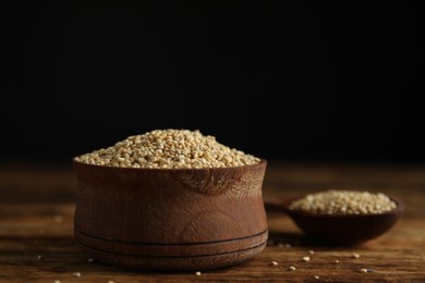 Bowl with white quinoa on wooden table. Space for text