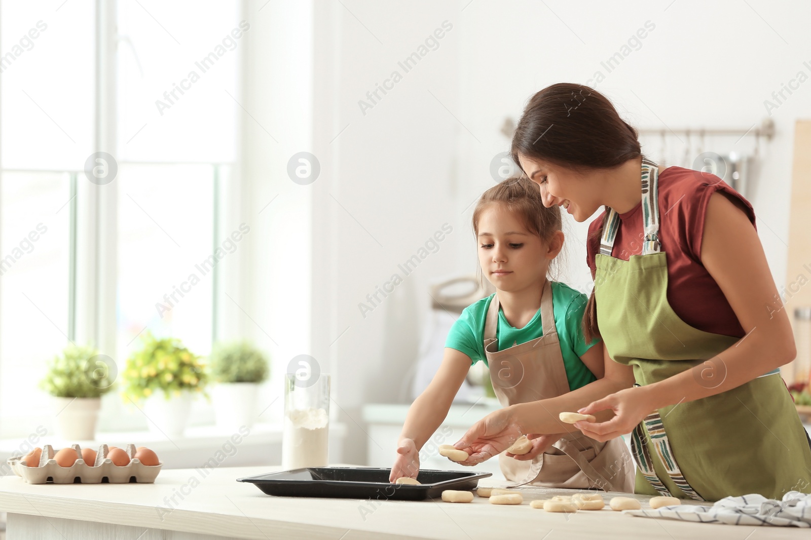 Photo of Mother and her daughter with cookie dough in kitchen