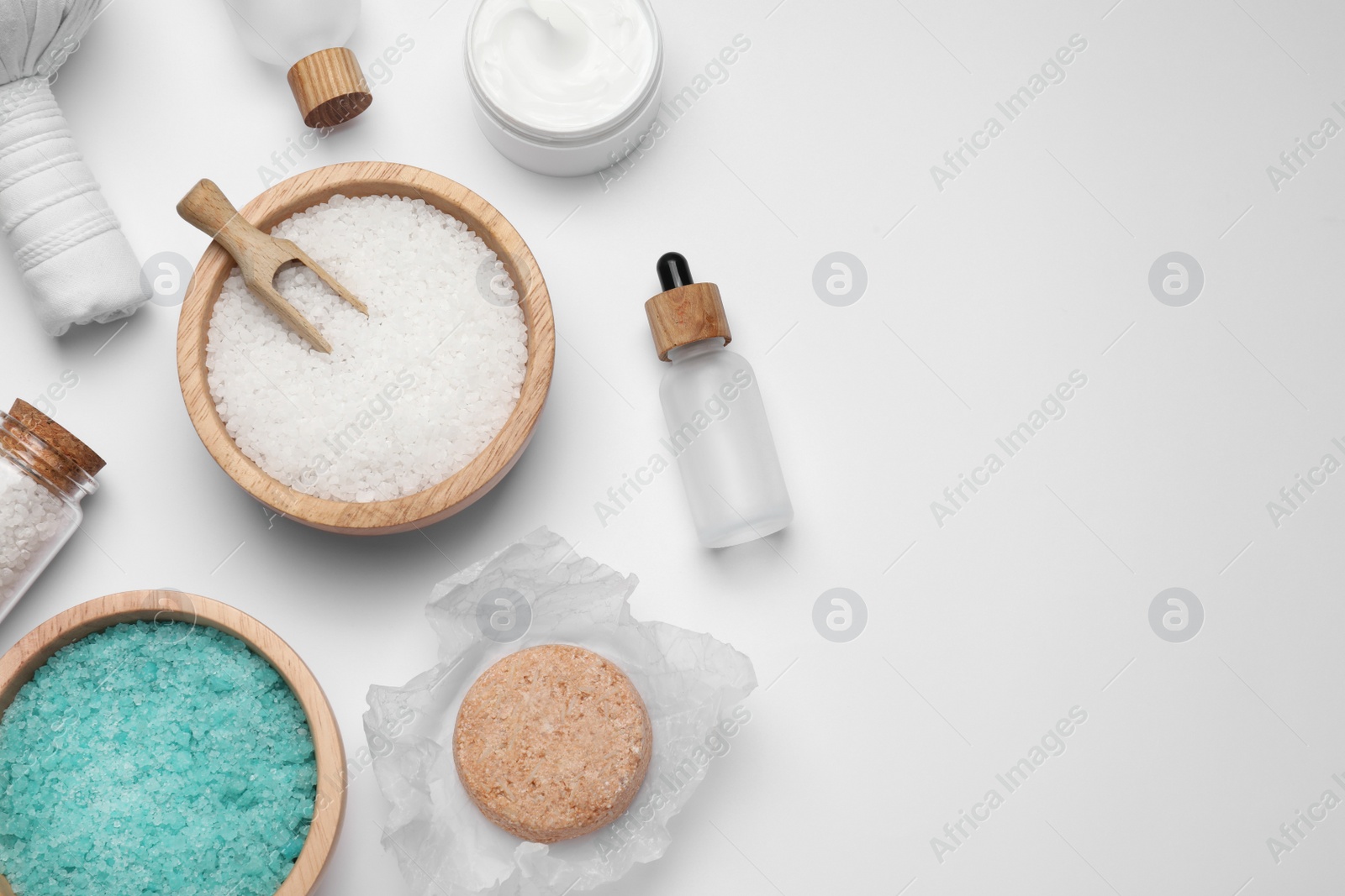 Photo of Beautiful spa composition with herbal massage bag and different care products on white background, flat lay. Space for text