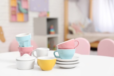 Photo of Toy dishware on small table in child's room, closeup