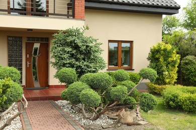 Photo of Picturesque view of beautiful house and garden on sunny day