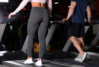 Couple working out on treadmill in gym, closeup
