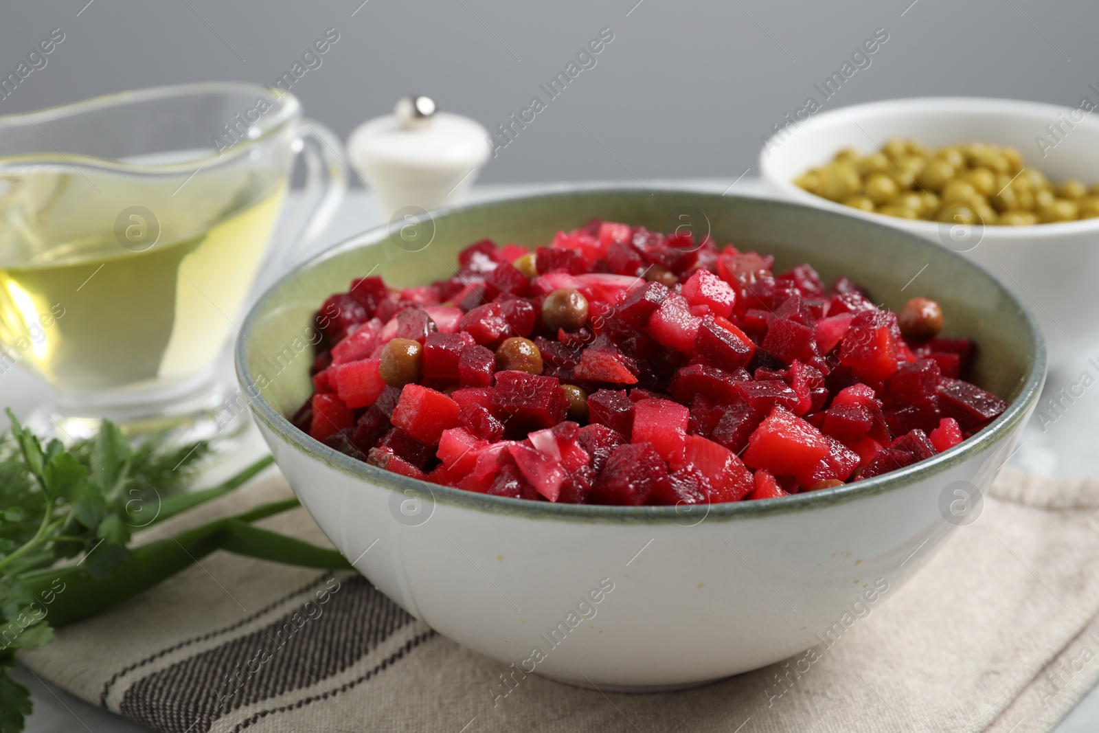 Photo of Bowl of delicious fresh vinaigrette salad on table, closeup
