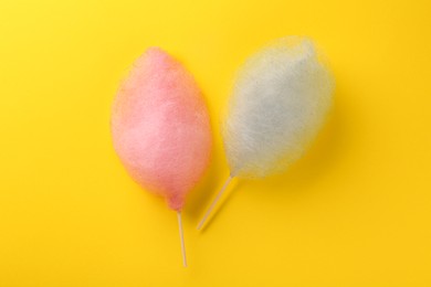 Photo of Sweet color cotton candies on yellow background, flat lay