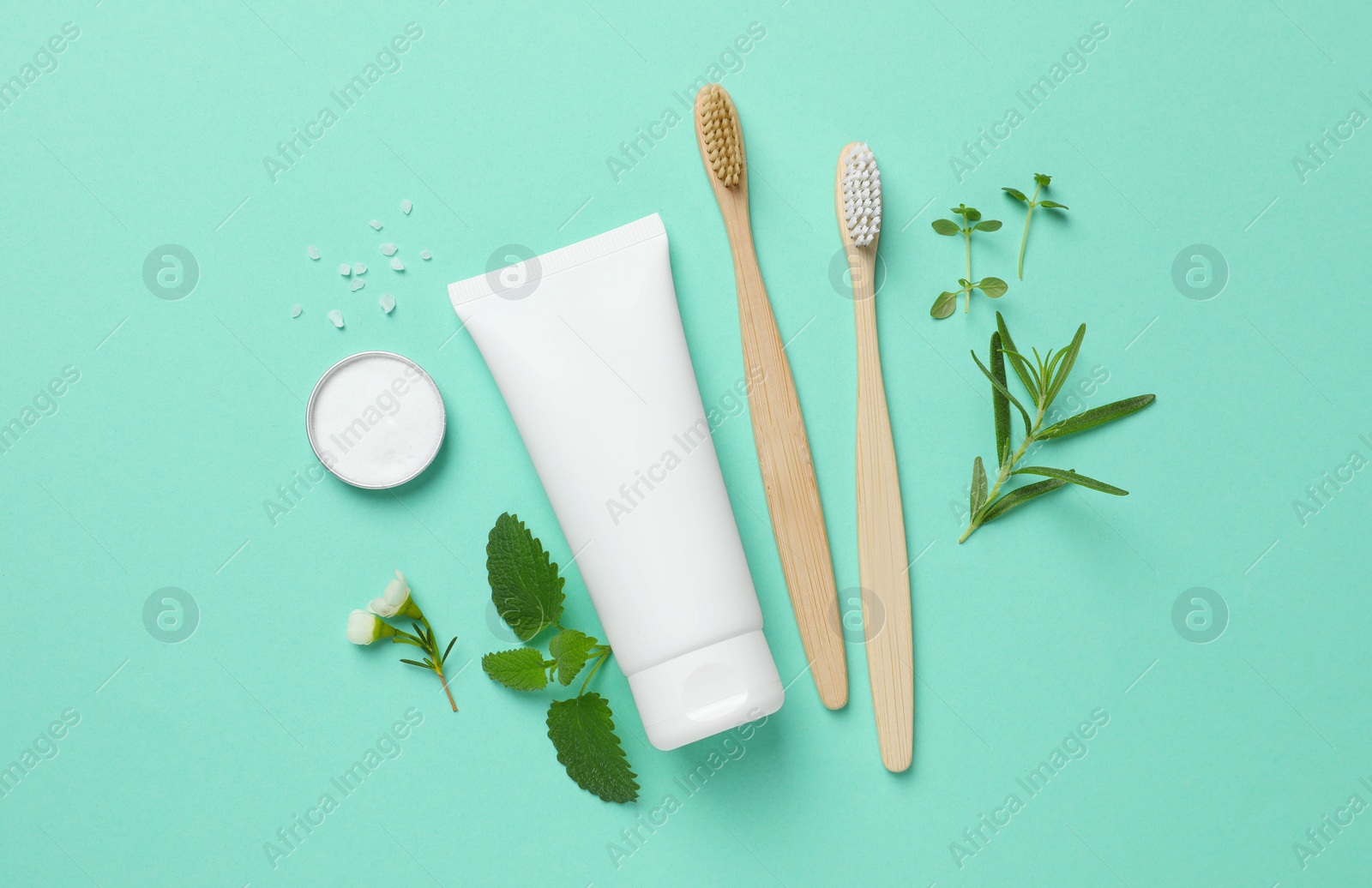 Photo of Flat lay composition with bamboo toothbrushes and herbs on turquoise background