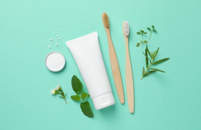 Flat lay composition with bamboo toothbrushes and herbs on turquoise background
