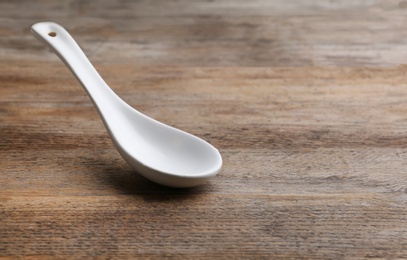 Clean empty miso spoon on wooden background, space for text