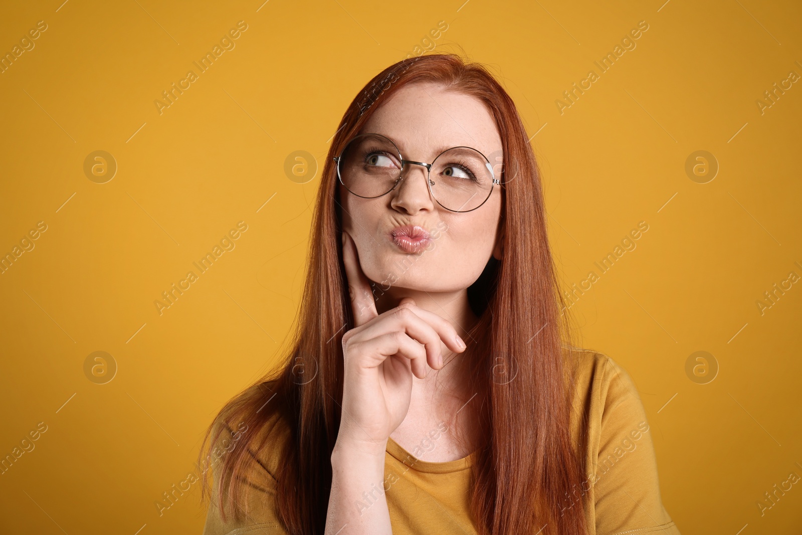 Photo of Portrait of thoughtful young woman with gorgeous red hair on yellow background