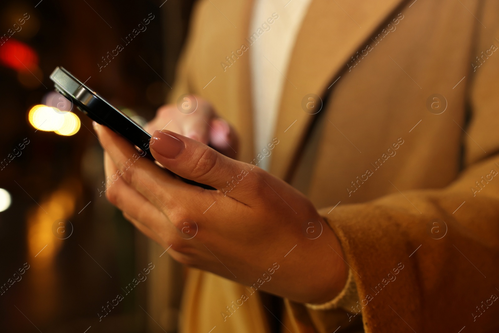 Photo of Woman using smartphone on blurred background, closeup