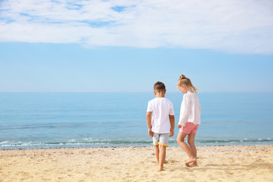 Photo of Cute little children on sea beach outside