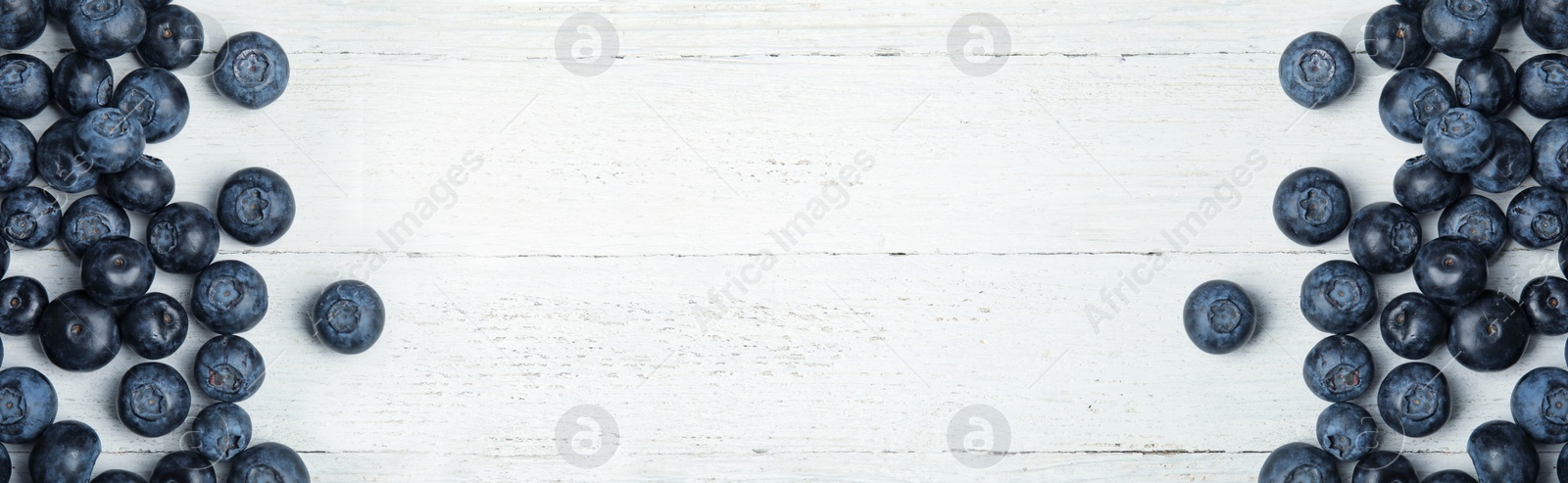 Image of Tasty fresh blueberries on white wooden table, flat lay with space for text. Banner design