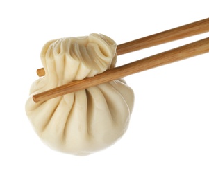 Photo of Chopsticks with tasty dumpling isolated on white