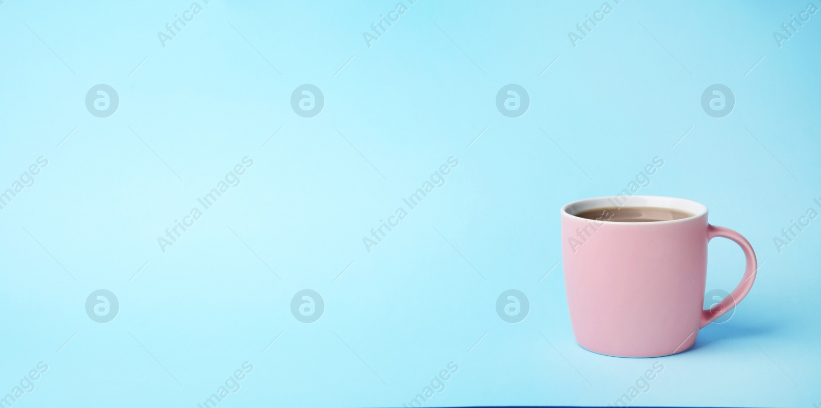 Photo of Pink ceramic cup with hot aromatic coffee on color background