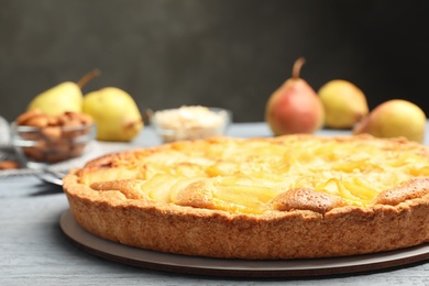 Delicious sweet pear tart on grey wooden table