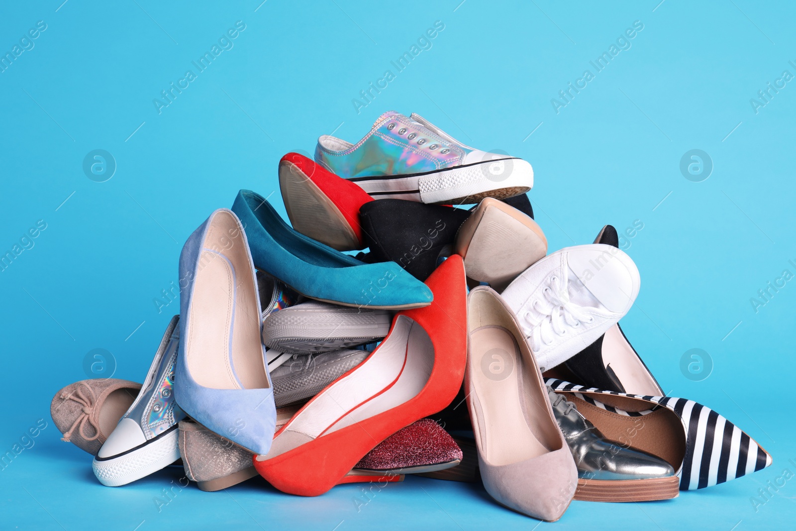 Photo of Heap of different shoes on color background