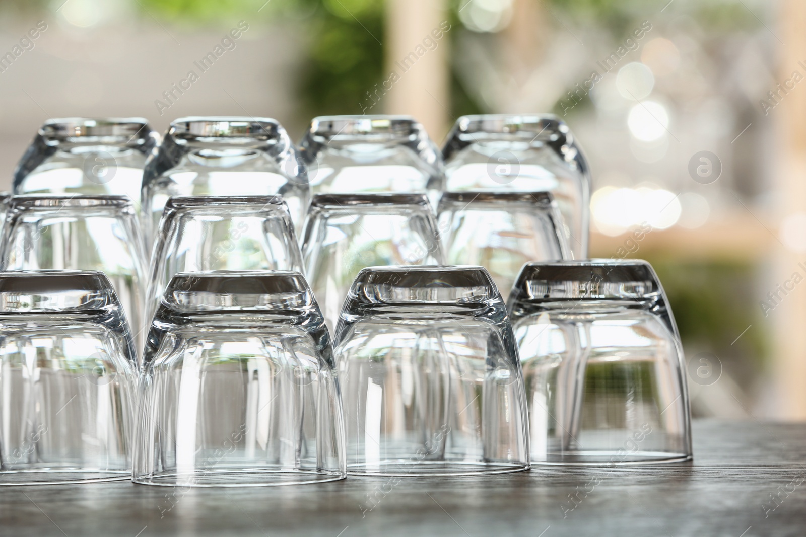 Photo of Empty glasses on wooden table against blurred background