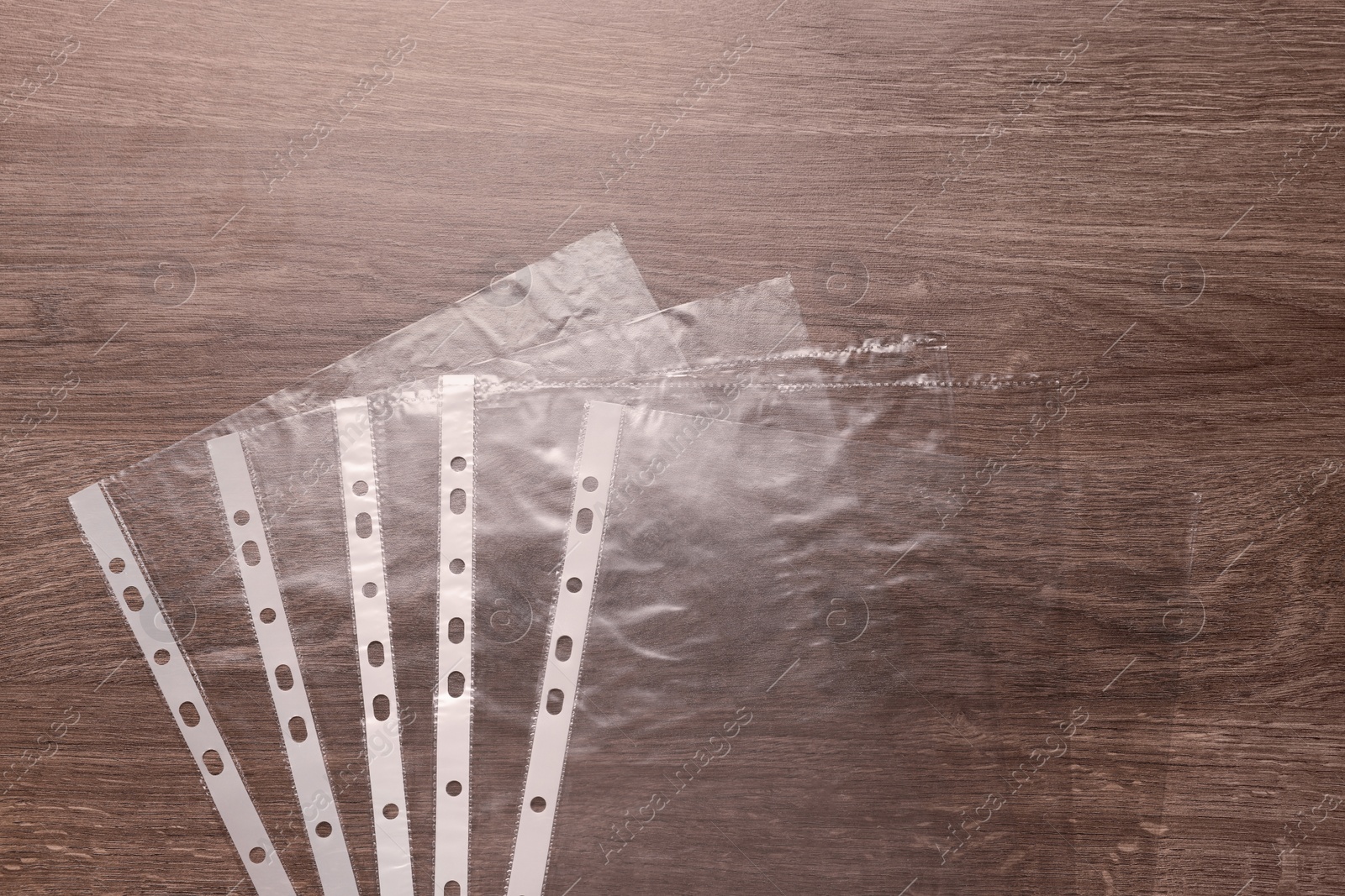 Photo of Punched pockets on wooden table, flat lay