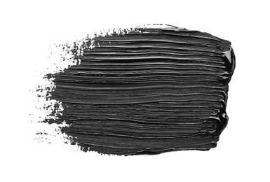 Photo of Brushstrokes of black oil paint on white background, top view