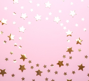 Photo of Frame made of confetti stars with space for text on pink background, top view. Christmas celebration