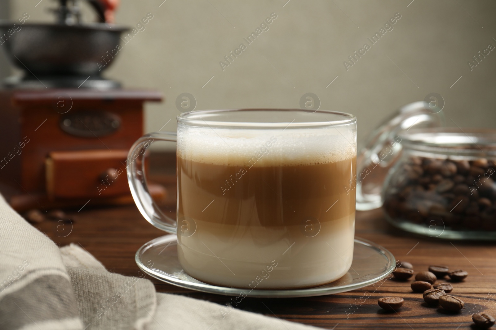 Photo of Aromatic coffee in cup and beans on wooden table