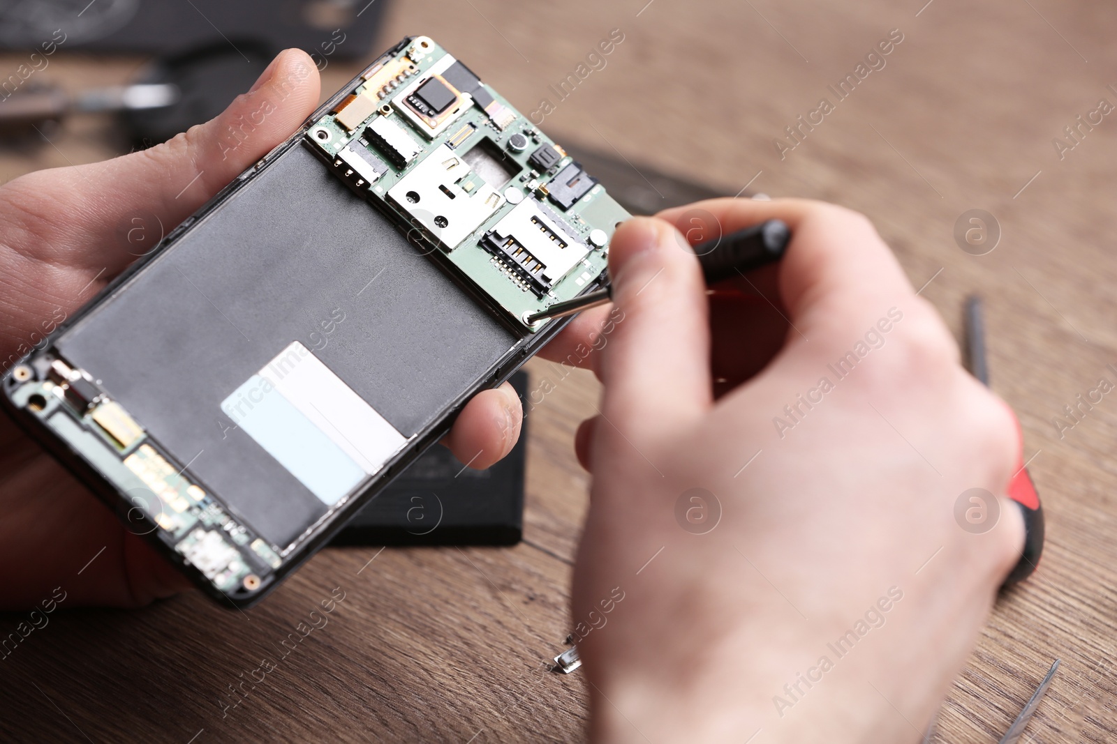 Photo of Technician fixing mobile phone at table, closeup. Device repair service