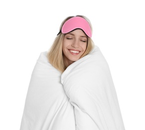 Photo of Young woman in sleeping mask wrapped with soft blanket on white background