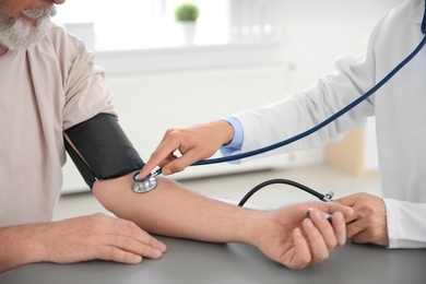 Photo of Doctor measuring patient's blood pressure in hospital